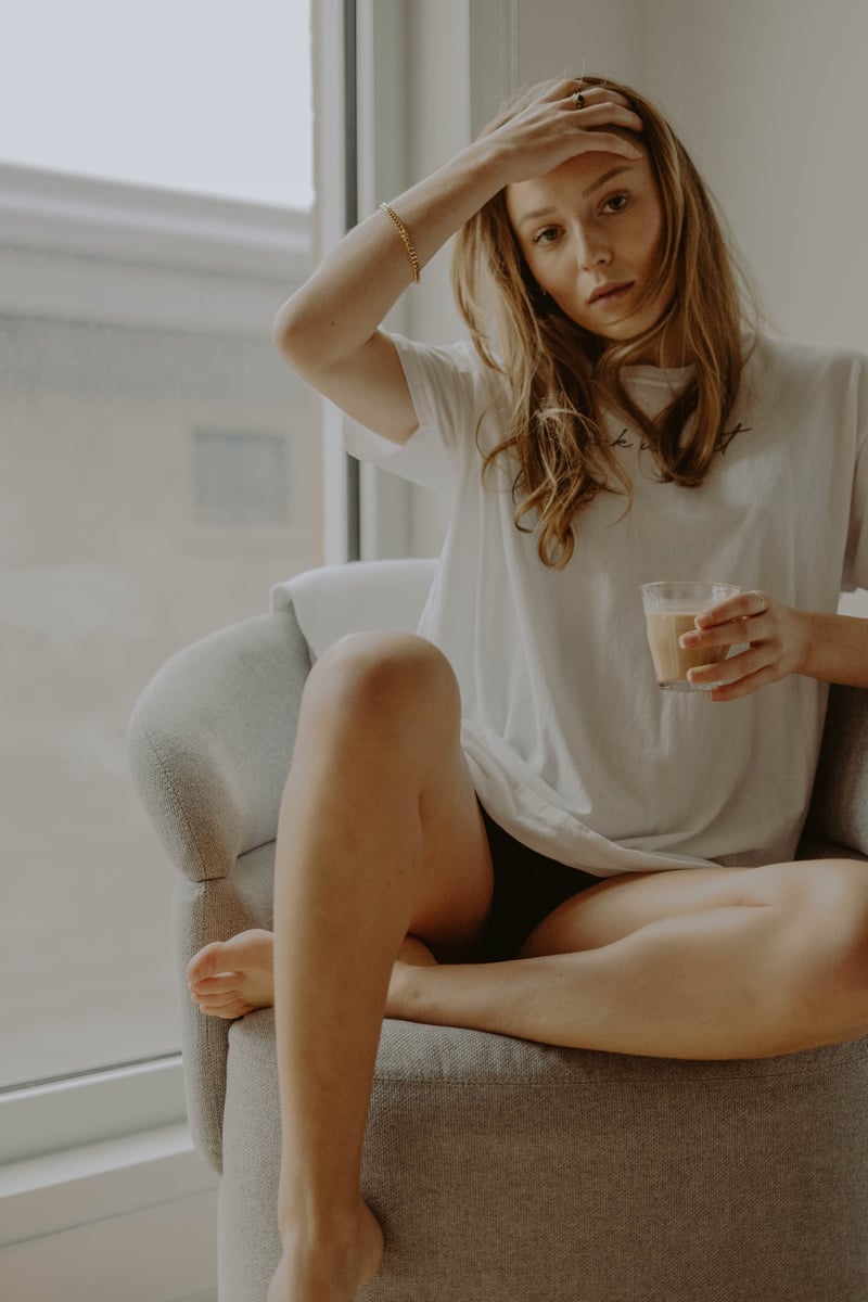 Woman in White Shirt Sitting on White Couch